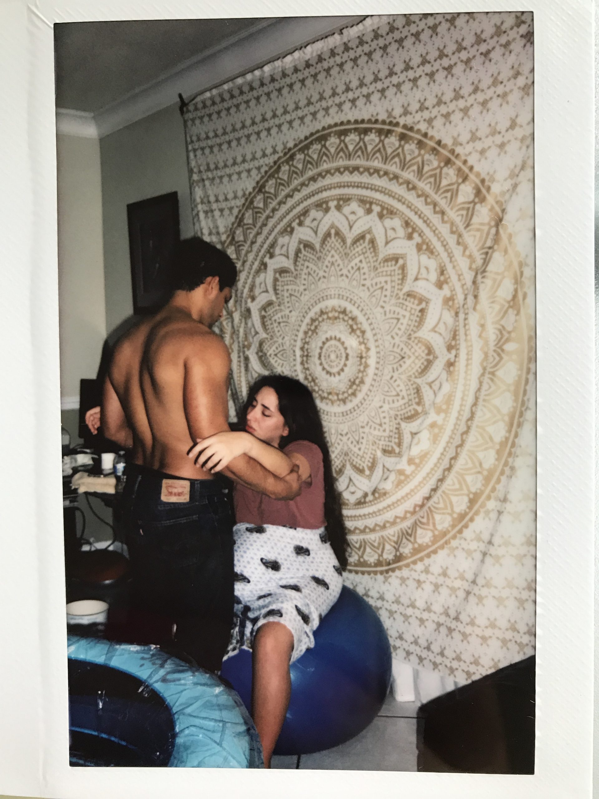 polaroid of woman in labor on yoga ball held by husband