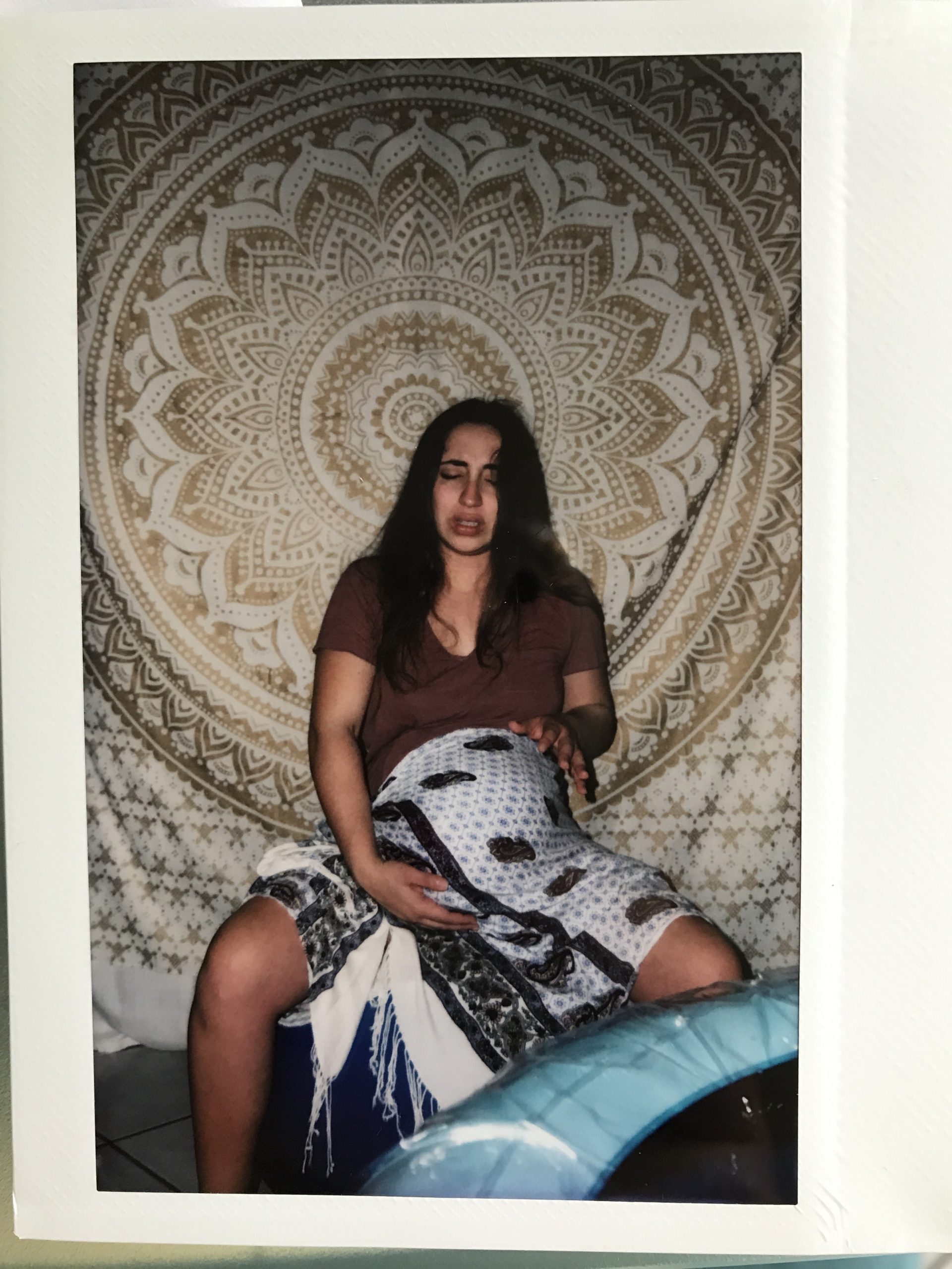polaroid of pregnant woman in labor and in pain on yoga ball