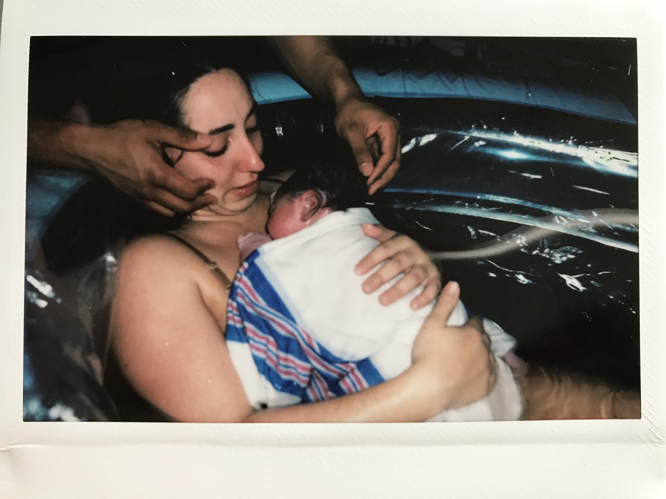 mother holding baby in birth pool